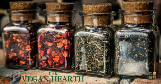 Glass jars filled with dried garden herbs and spices, perfect for seasoning a vegan chili recipe.